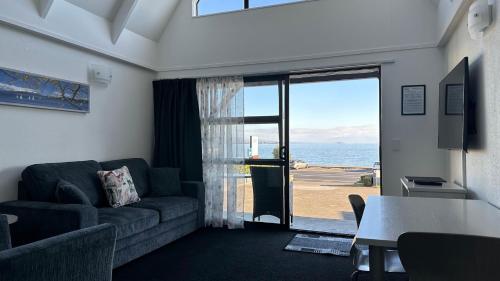 a living room with a couch and a view of the ocean at Gables Lakefront Resort in Taupo