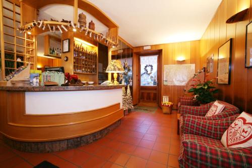 a bar in a restaurant with two couches in a room at Hotel Ruitor in Arvier