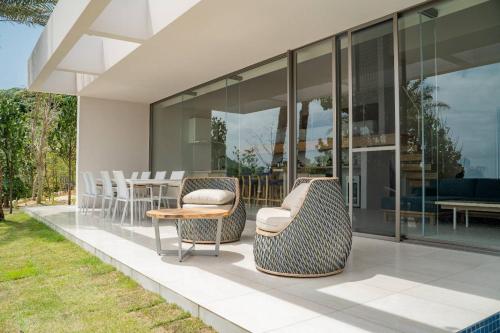 a glass house with chairs and a table at THE PANALI in Miyako Island