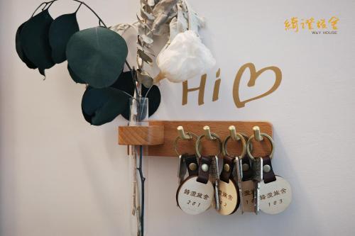 a wall with a wooden rack with wine hangers at 寮寓x綺澄 in Xiaoliuqiu