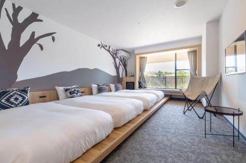 Miki的住宿－神戶雀巢度假酒店，有一排床,在一间有树壁画的房间
