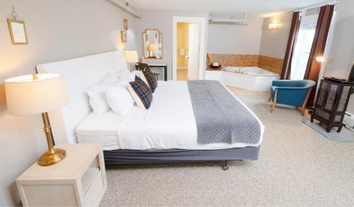 a bedroom with a large bed and a bathroom at The New London Inn in New London