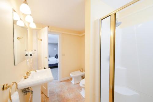 a bathroom with a sink and a toilet and a mirror at The New London Inn in New London