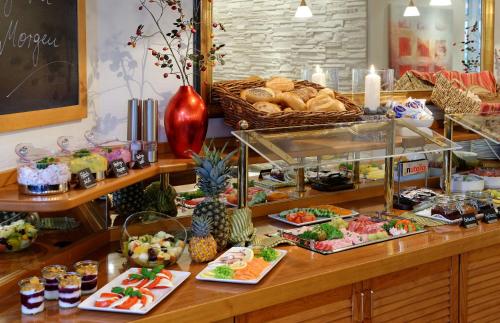 a buffet with a lot of food on a table at Trend Hotel in Oldenburg