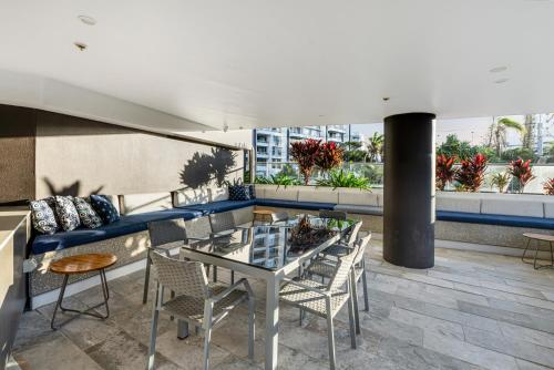 a balcony with a table and chairs and a couch at Rhapsody Resort - Official in Gold Coast