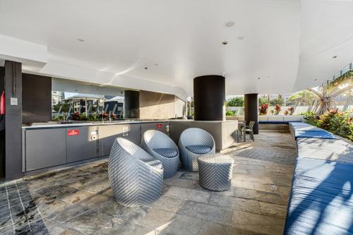 a lobby with blue and white chairs and a counter at Rhapsody Resort - Official in Gold Coast