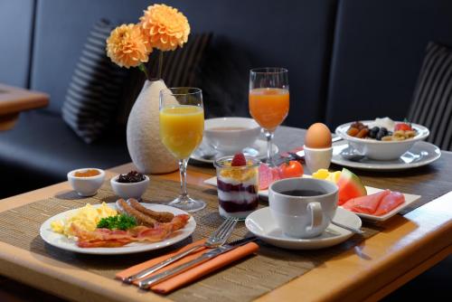 a table with breakfast foods and drinks on it at Trend Hotel in Oldenburg