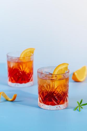 two glasses of orange cocktails on a blue table at The Five Residences Hanoi in Hanoi
