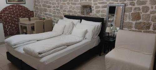 a bed with white pillows on it in a room at Antea in Split