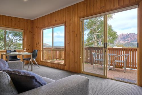 コールズ・ベイにあるFreycinet Sanctuary 4のリビングルーム(ガラスのスライドドア、テーブル、椅子付)