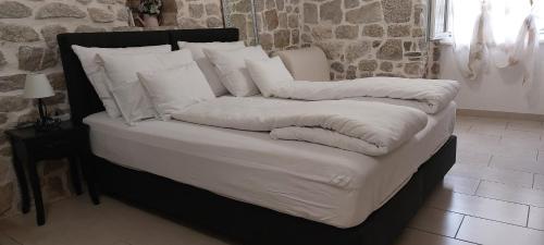 斯普利特的住宿－安蒂公寓，一张带白色床单和枕头的床