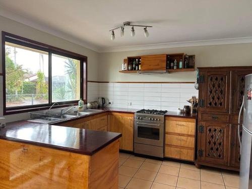 a kitchen with wooden cabinets and a stainless steel appliance at House and Van on the River in Tweed Heads