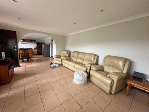 a living room with leather couches in a room at House and Van on the River in Tweed Heads
