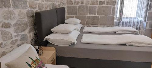 a stack of white pillows sitting on a bed at Antea in Split