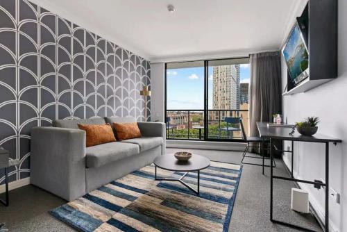 a living room with a couch and a table at KozyGuru | Haymarket | Central City Studio in Sydney