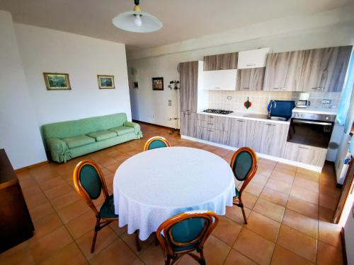 sala de estar con mesa y sillas y cocina en Casa Ghirlanda appartamenti en Lazise