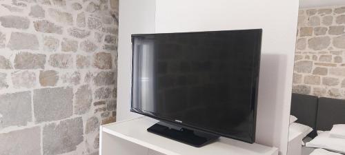 a large flat screen tv sitting on a white cabinet at Antea in Split