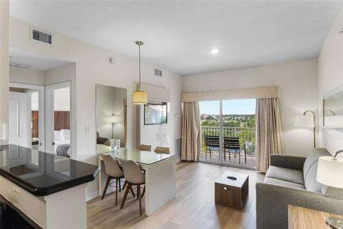 a kitchen and living room with a dining table and a living room at Premier Resort Condos Near Disney & Universal in Orlando
