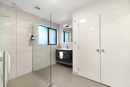 a bathroom with a glass shower and a sink at Town centre house. Perfect for families and groups in Queenstown