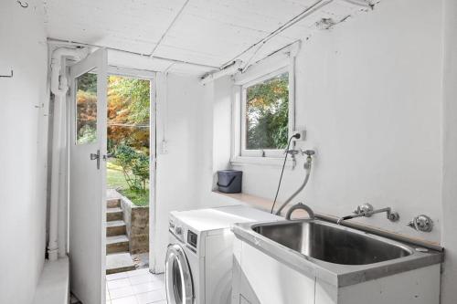 una cucina con lavello e lavatrice di Detached Queen Room in Pymble - Serene Spot - Shared Bathroom a Pymble