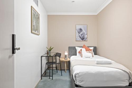 una camera da letto con un letto e un tavolo con una sedia di Cozy Single Room in Pymble - Quaint Place - Shared Bathroom a Pymble