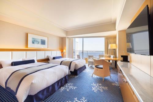 a hotel room with two beds and a flat screen tv at The Yokohama Bay Hotel Tokyu in Yokohama