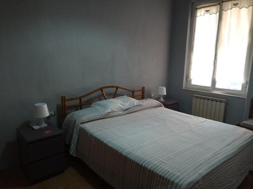 a bedroom with a bed and two windows at Casa marzia in La Spezia