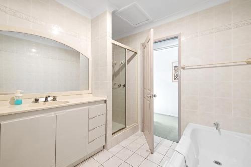 a white bathroom with a sink and a shower at Detached Single Room - Central Spot in Pymble - Shared Bathroom in Pymble