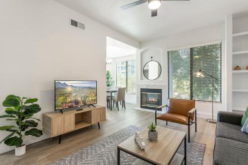 ein Wohnzimmer mit einem TV und einem Kamin in der Unterkunft 2BR CozySuites at Kierland Commons with pool #11 in Scottsdale
