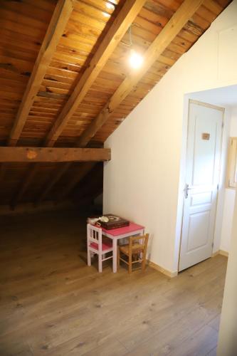 a room with a red table in a attic at Les Curtillets in Bellevaux
