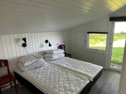 um quarto com uma cama e uma janela em Beautiful Located Holiday Home In The First Row To The Beach em Haderslev