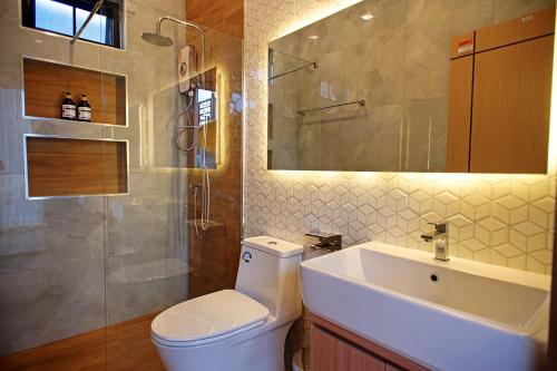 a bathroom with a toilet and a sink and a mirror at Nattarin Pool Villa Pattaya-Na Chom Thian in Ban Map Fakthong