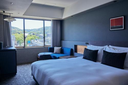 京都市にあるノーガホテル清水京都の大きなベッドと窓が備わるホテルルームです。