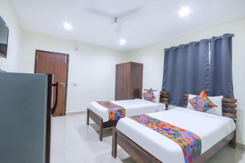 a bedroom with two beds and a tv in it at FabHotel SK Grand in Hyderabad