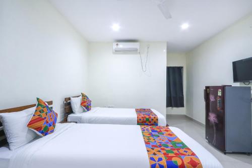 a hotel room with two beds and a television at FabHotel SK Grand in Hyderabad