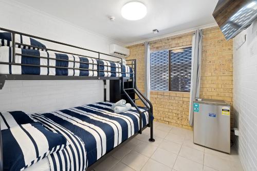 1 dormitorio con 2 literas y ventana en Motel Sunshine Coast en Caloundra