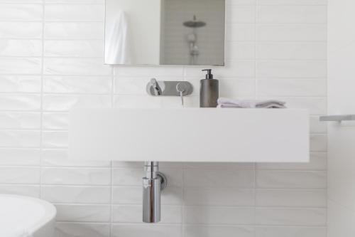 a white bathroom with a sink and a mirror at Ocean Escape, Pet Friendly in Ocean Grove
