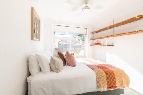 a bedroom with a bed with pillows and a window at Ocean Escape, Pet Friendly in Ocean Grove