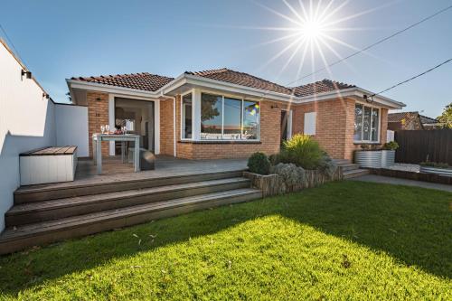 a home with a wooden deck in a yard at Ocean Escape, Pet Friendly in Ocean Grove