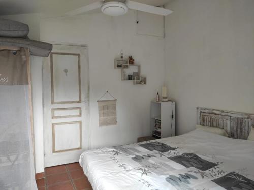 a white bedroom with a bed and a door at Maison la ciotat in La Ciotat