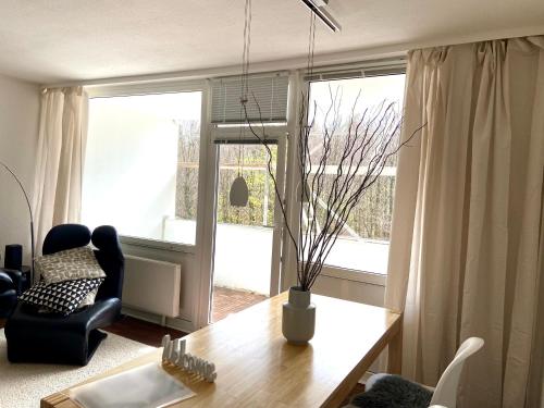 a living room with a table and a chair and a window at Harz is calling in Hahnenklee-Bockswiese