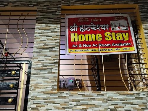 a home stay sign on the side of a building at Shree Hatkeshwar Home Stay Ujjain in Ujjain