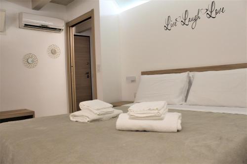 ein Schlafzimmer mit weißen Handtüchern auf dem Bett in der Unterkunft More Apartments il Ferrarese2 in Bari