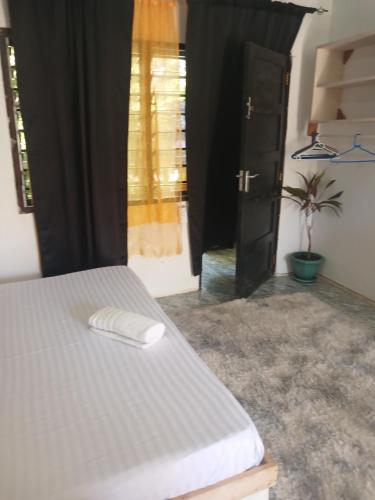 1 dormitorio con cama y ventana en Hildas Studio en Diani Beach