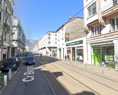 une rue de la ville avec des voitures garées dans la rue dans l'établissement T2 Berriat - Proche Gare & Centre - Tout Equipé avec Wifi, à Grenoble