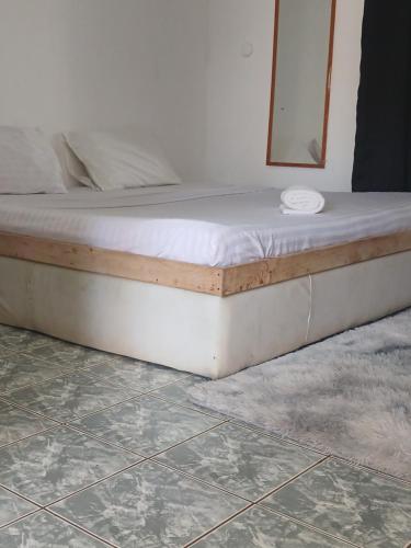 Bett in einem Zimmer mit einer weißen Matratze in der Unterkunft Hildas Studio in Diani Beach