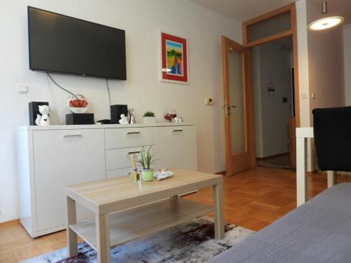 a living room with a table and a tv on a wall at AppLuna in Zagreb