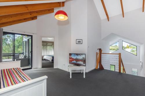a living room with a couch and a tv in it at Dunsborough Beach Villa in Quindalup