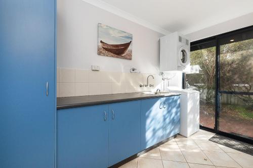 a kitchen with blue cabinets and a sink at Dunsborough Beach Villa in Quindalup
