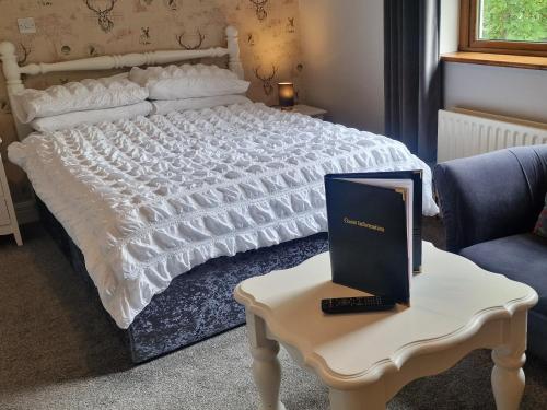 een slaapkamer met een bed en een laptop op een tafel bij Church View House in Gorteen